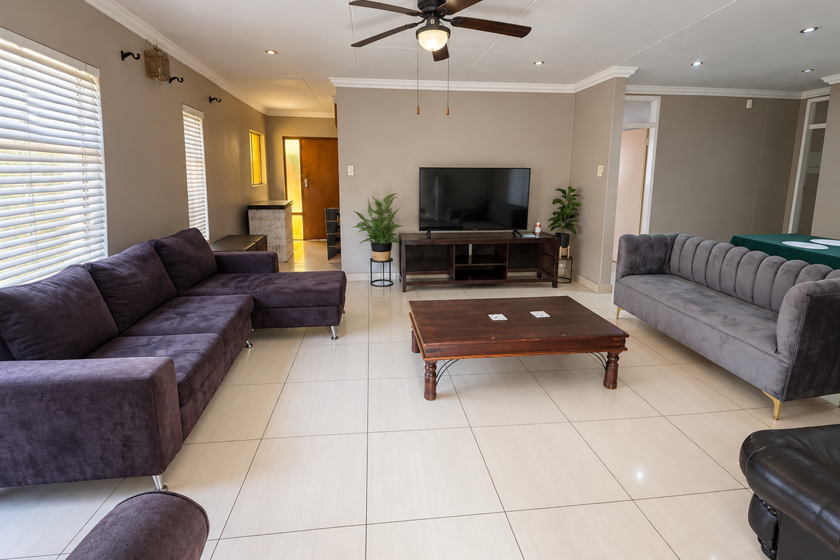 Spacious living room featuring neutral tiled flooring, recessed lighting, a ceiling fan, and large windows with venetian blinds.
