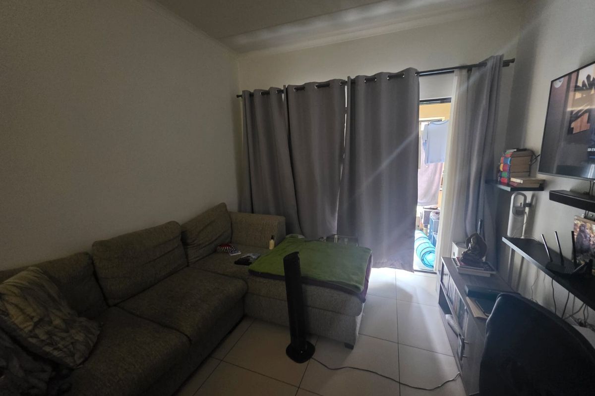 A living room featuring tiled flooring and a sliding door providing access to an outdoor area.