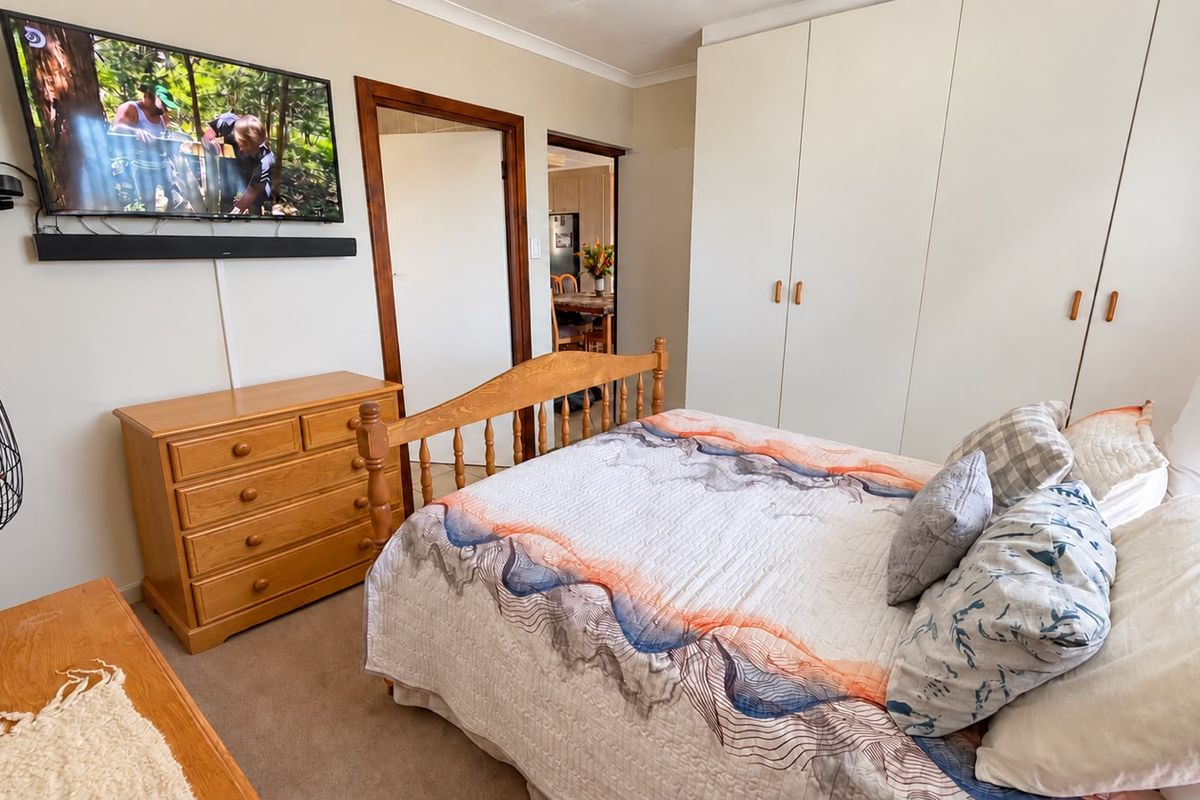 A functional bedroom featuring built-in cupboards, neutral wall finishes, and coving, providing a comfortable and practical living space.