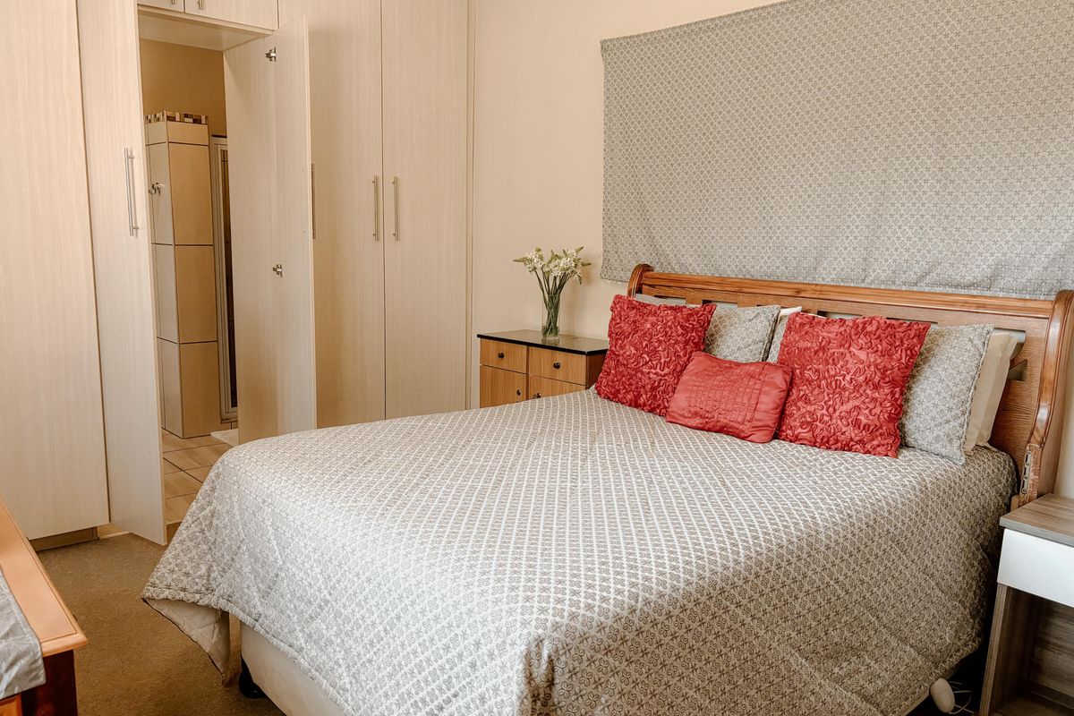 A bedroom featuring built-in cabinetry and an en-suite bathroom access, providing functional storage and a practical layout.