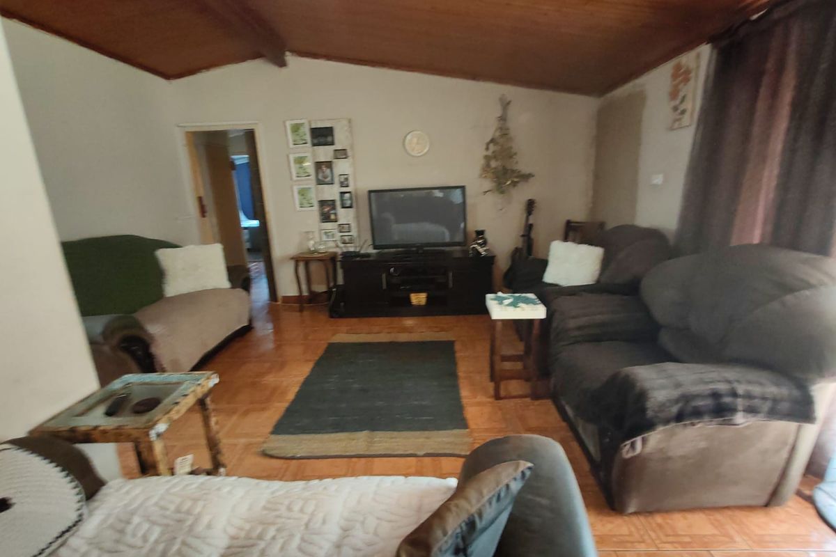 A living room featuring a vaulted timber-clad ceiling and tiled flooring, requiring minor wall repairs to complete the interior finish.