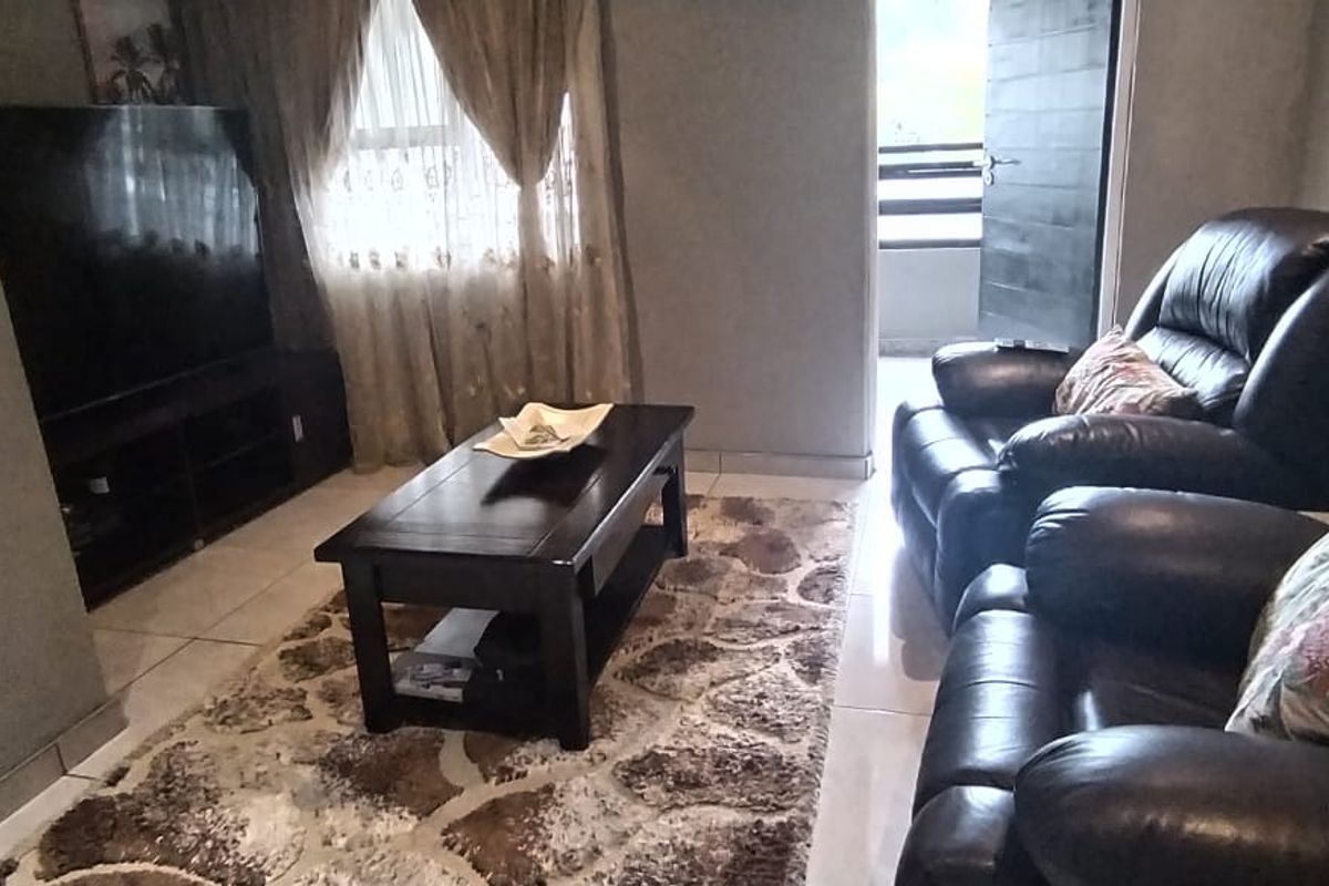 A living room featuring tiled flooring and direct access to an outdoor balcony area.