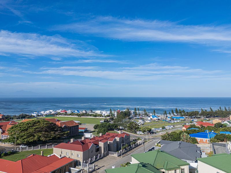 A scenic elevated view overlooking the coastal neighborhood, surrounding residential properties, and the ocean horizon.
