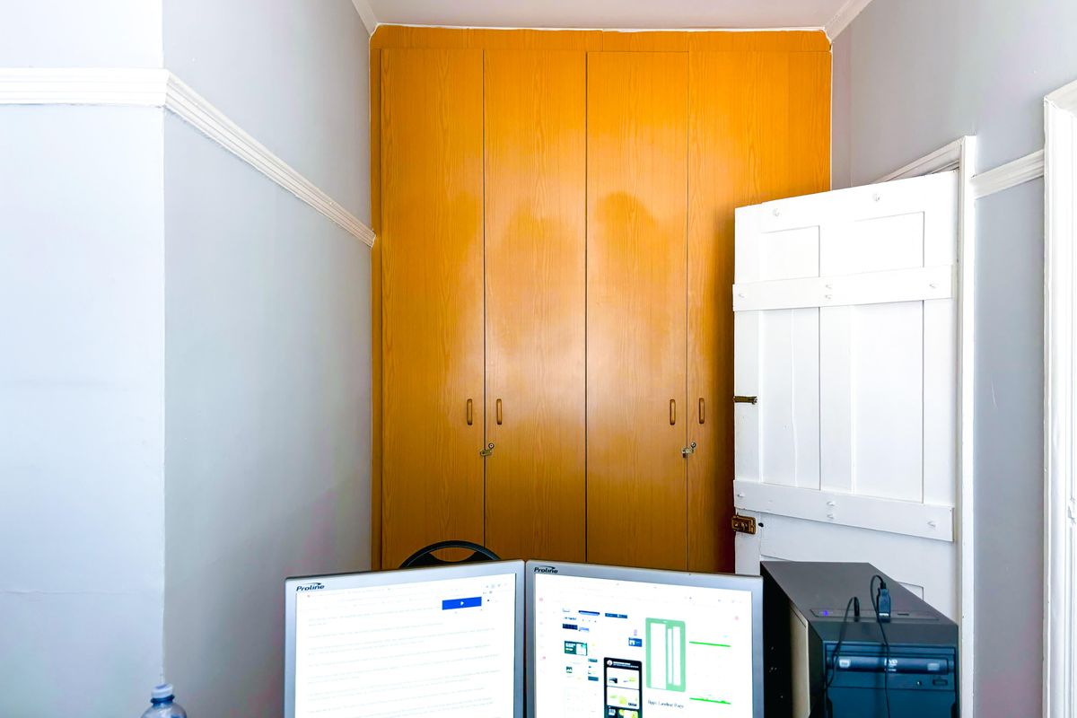 A bedroom featuring classic built-in wooden cupboards, decorative picture rails, and traditional cornice detailing.
