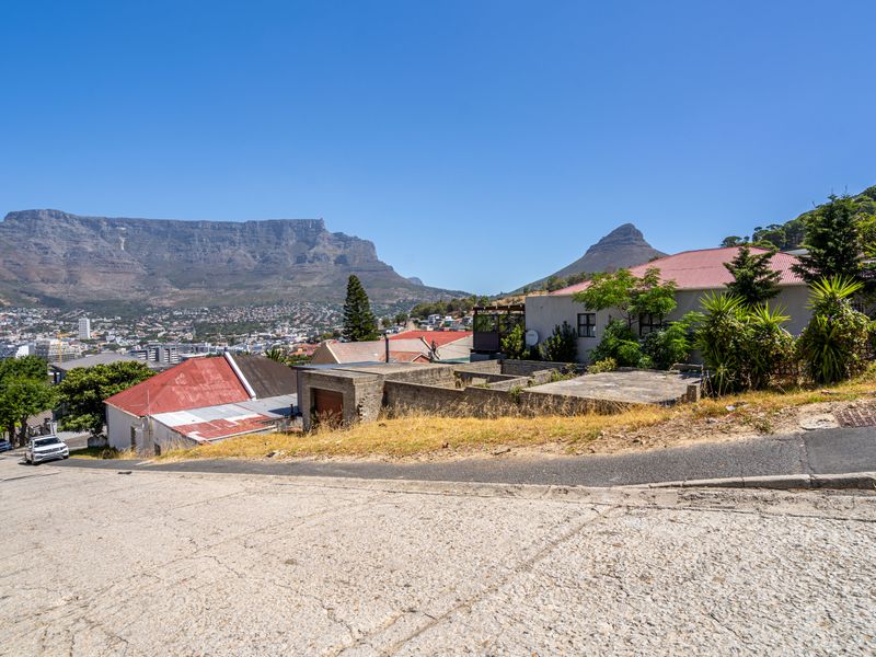 Street view of the property showing the exterior facade, driveway, and surrounding landscape with prominent mountain views in the background.