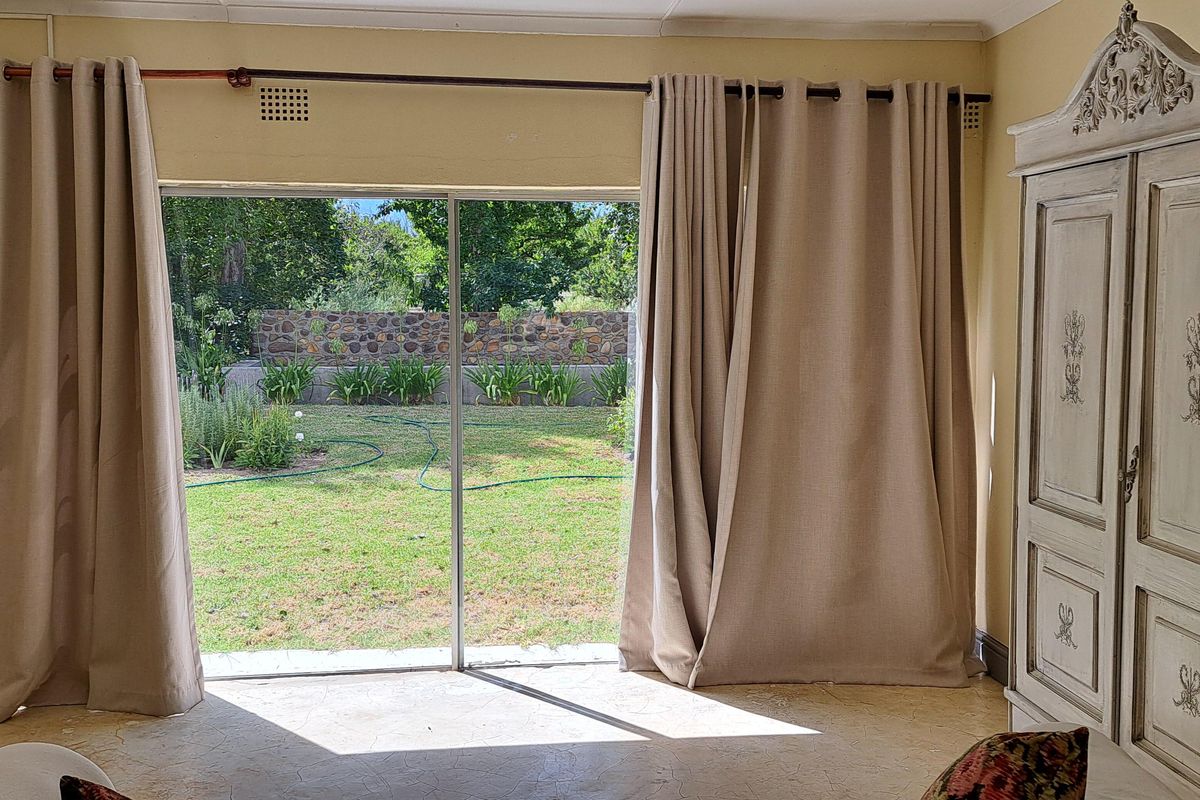 A living room featuring large sliding glass doors that provide direct access to the rear garden and patio area.
