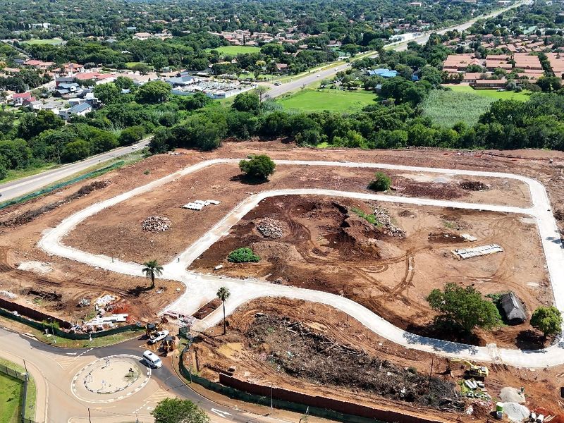 Aerial view of a residential development site showing cleared land, established internal road infrastructure, and surrounding suburban landscape.