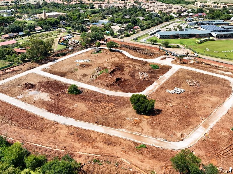 Aerial view of a residential development site featuring cleared land and newly constructed internal paved roads.