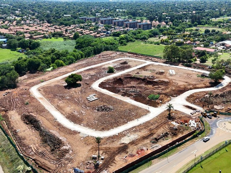 Aerial view of a residential development site showing cleared land, established internal road infrastructure, and surrounding suburban landscape.