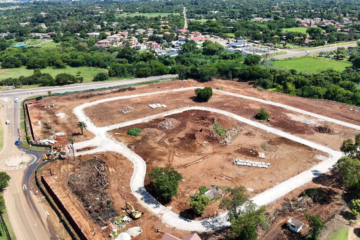 Aerial view of a residential development site showing cleared land, established internal road infrastructure, and surrounding suburban landscape.