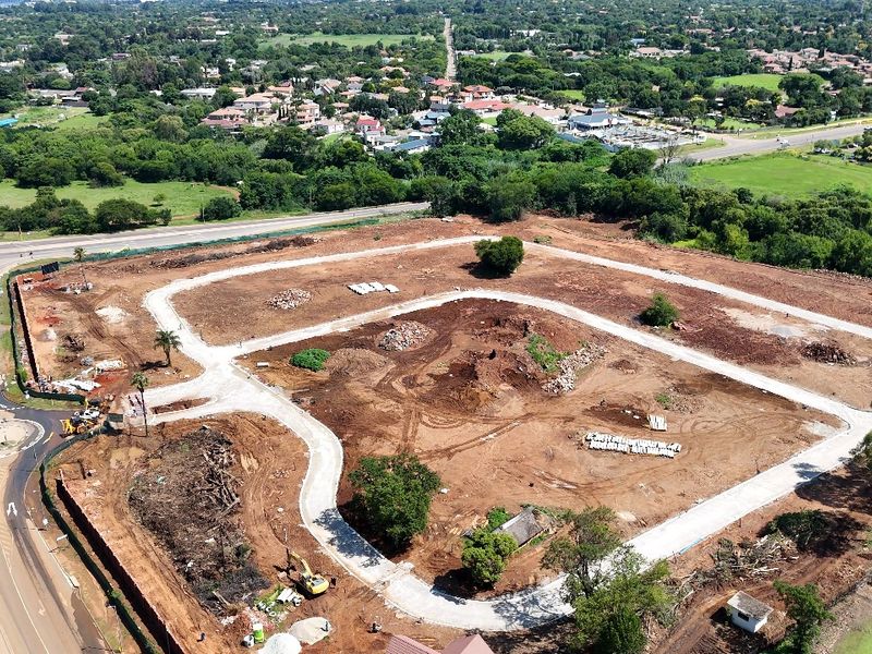 Aerial view of a residential development site showing cleared land, established internal road infrastructure, and surrounding suburban landscape.