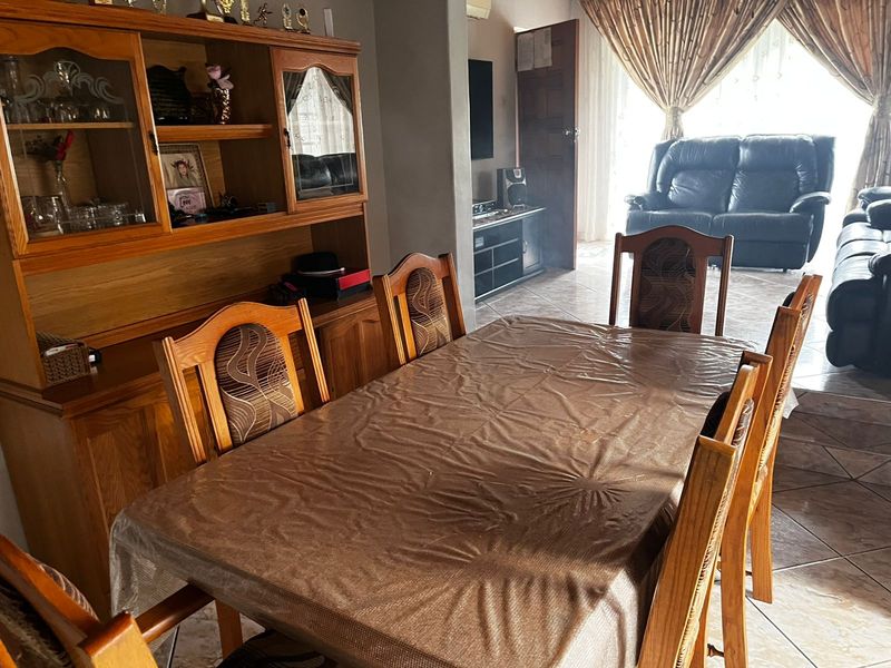 A dining room area featuring tiled flooring, providing a functional space for family meals and gatherings.