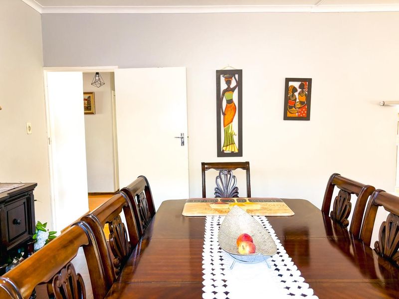 A dining room area featuring a neutral wall finish and a doorway leading to an adjacent hallway.