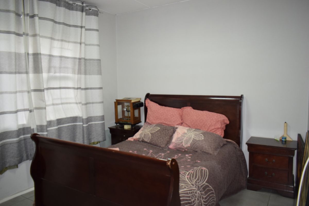 A standard bedroom featuring tiled flooring and neutral wall finishes, providing a functional space for rest.