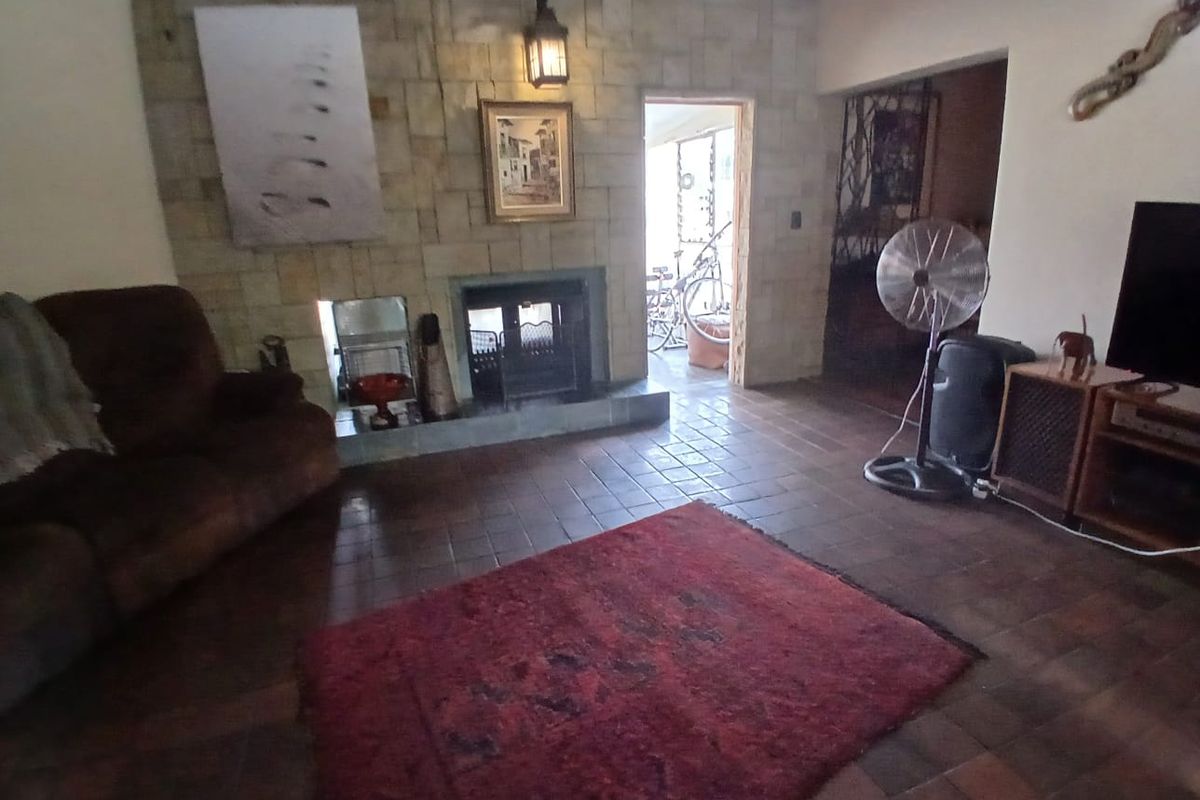 Living room featuring a stone fireplace, tiled flooring, and direct access to an outdoor area.