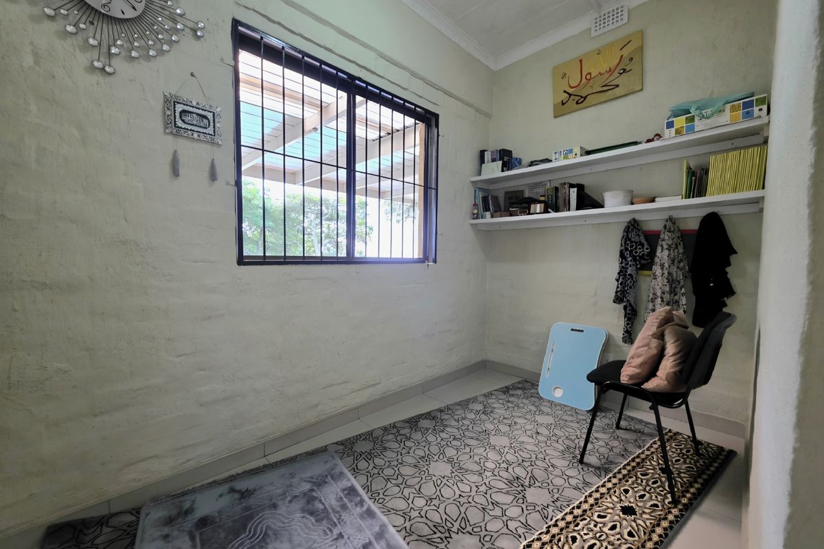 A compact bedroom featuring tiled flooring, built-in wall shelving, and a window fitted with security bars.
