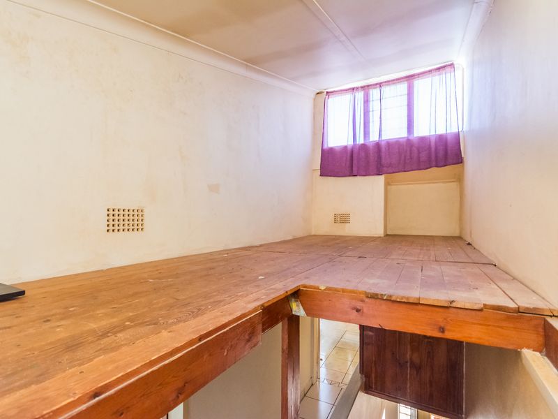 An empty mezzanine level featuring timber flooring and support beams, requiring cosmetic updates to improve the overall finish and appeal of the space.