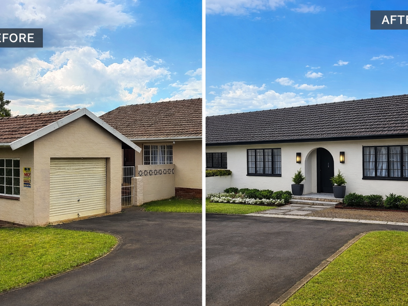 A renovated front facade featuring a modern arched entrance, dark window frames, and a clean paved walkway leading to the main house.