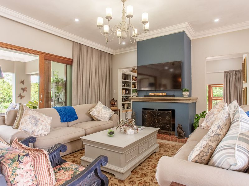 Spacious living room featuring a prominent fireplace with a blue feature wall, built-in shelving, and large sliding glass doors leading to the patio.