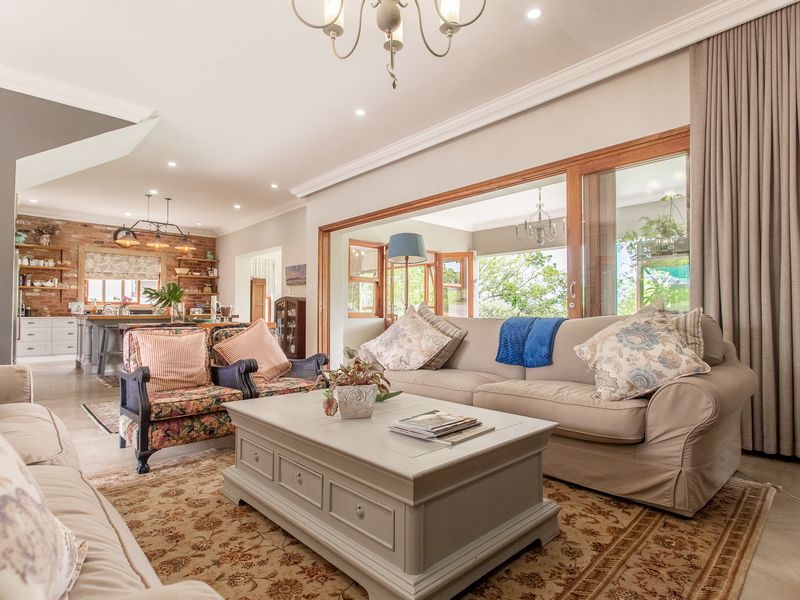 Spacious open-plan living area featuring a seamless flow to the kitchen, exposed brick accents, and large sliding doors opening to the outdoors.