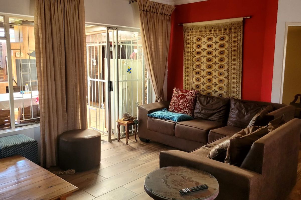A living room featuring tiled flooring and sliding glass doors that provide access to an outdoor patio area.