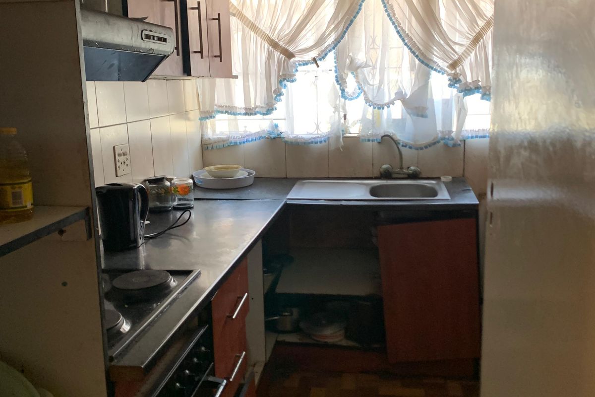 A dated kitchen featuring built-in cabinetry, an electric hob, and an oven, requiring significant renovation and modernization of finishes.