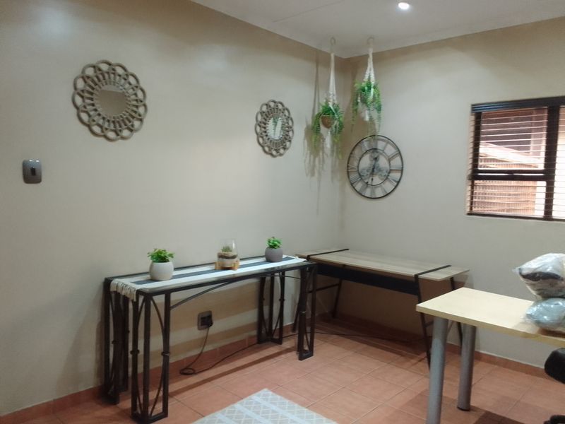 A functional office space featuring tiled flooring, recessed downlighting, and venetian blinds, providing a neutral base for a home workspace.