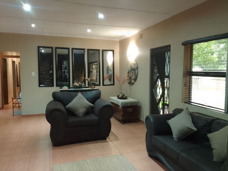 A living room featuring tiled flooring, recessed downlighting, and a security door with access to the exterior.