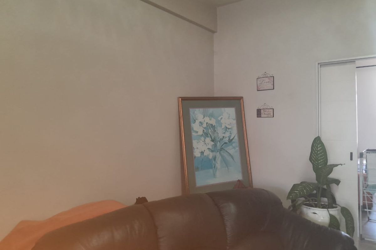 A living room area featuring a sliding door leading to an adjacent space, with neutral wall finishes.