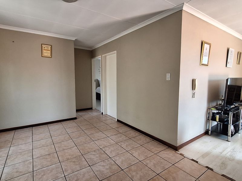 Open plan living area featuring tiled flooring, neutral wall finishes, and an intercom system, providing a functional layout for daily living.
