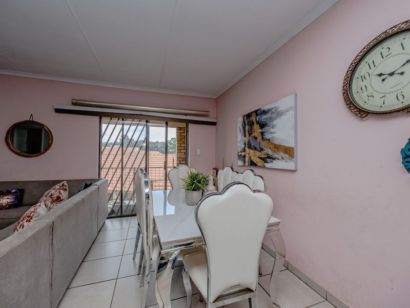 Open plan living and dining area featuring tiled flooring and a sliding glass door leading to an outdoor space.