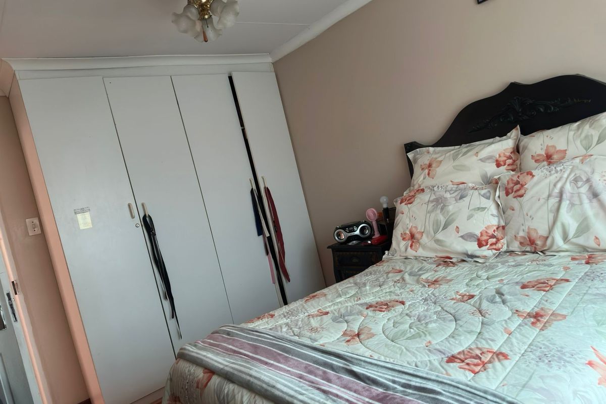 A bedroom featuring built-in cupboards and a ceiling fan, providing functional storage and climate control.