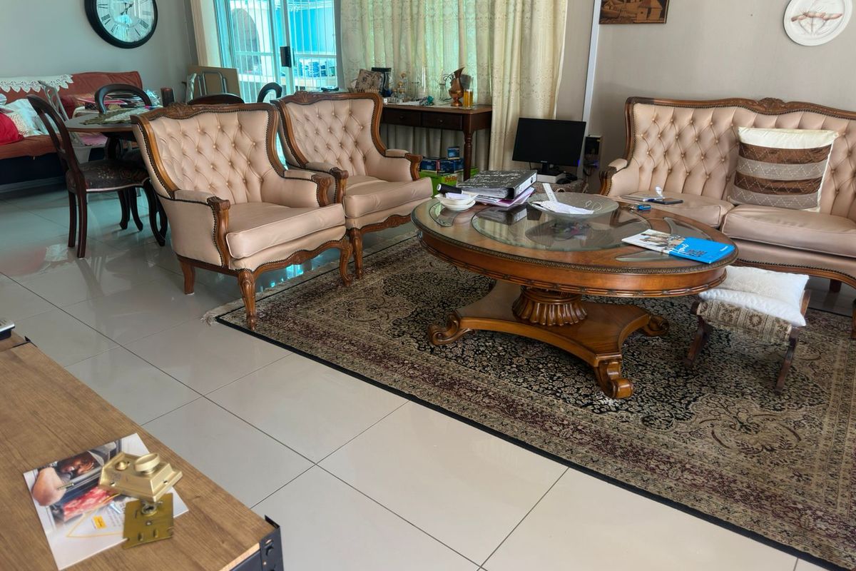 A spacious living room featuring large format floor tiles and a sliding glass door providing access to the outdoor area.