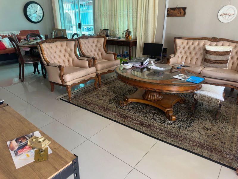 A spacious living room featuring large format floor tiles and a sliding glass door providing access to the outdoor area.