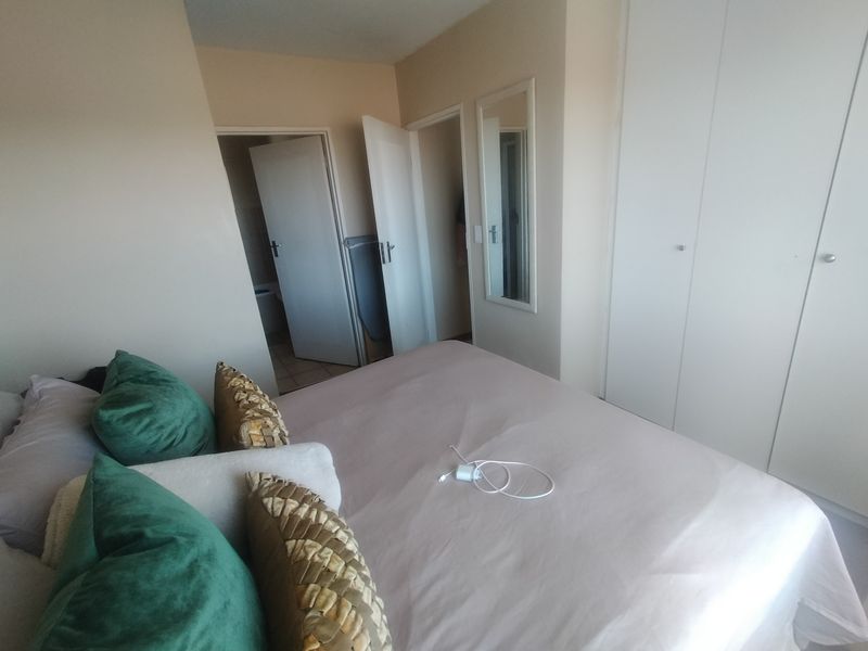 A bedroom featuring built-in cupboards, neutral wall finishes, and access to adjacent rooms through internal doors.