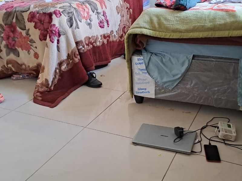 A bedroom featuring tiled flooring and standard electrical fixtures.