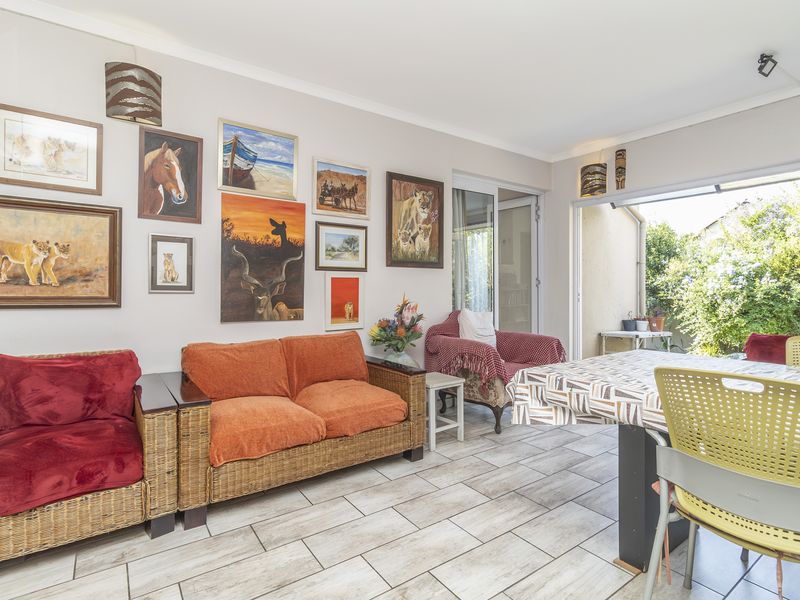 A bright living area featuring tiled flooring and large sliding glass doors that provide seamless access to the outdoor space.