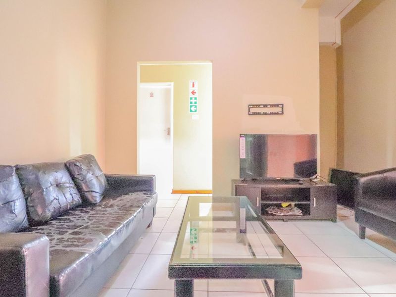 A living room area featuring tiled flooring and neutral wall finishes, providing a functional space for relaxation.