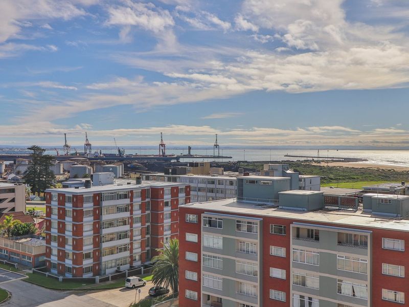Elevated panoramic view overlooking the surrounding urban apartment complex, harbour, and coastline.