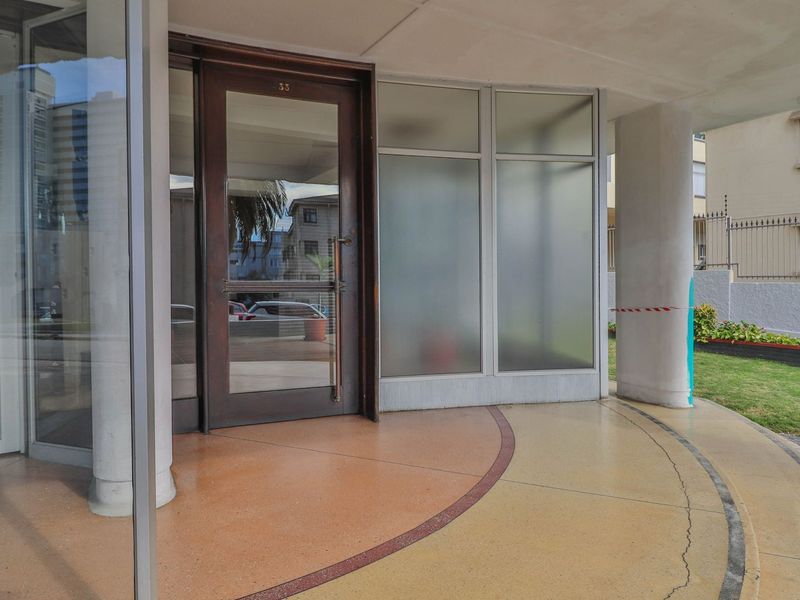 The apartment building entrance features a glass door, frosted glass panels, and terrazzo flooring, providing a clean and accessible entry point.