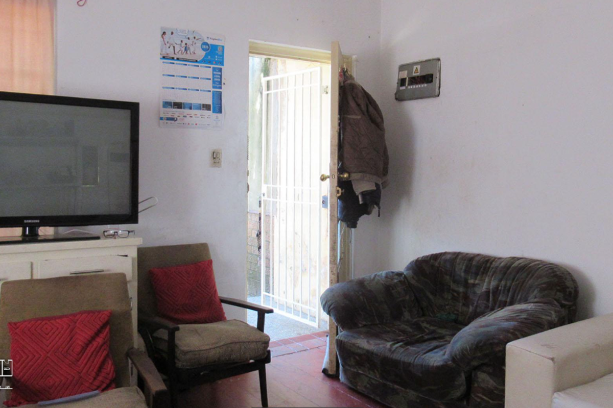 A living room area featuring a security gate at the entrance and a wall-mounted electrical distribution board.