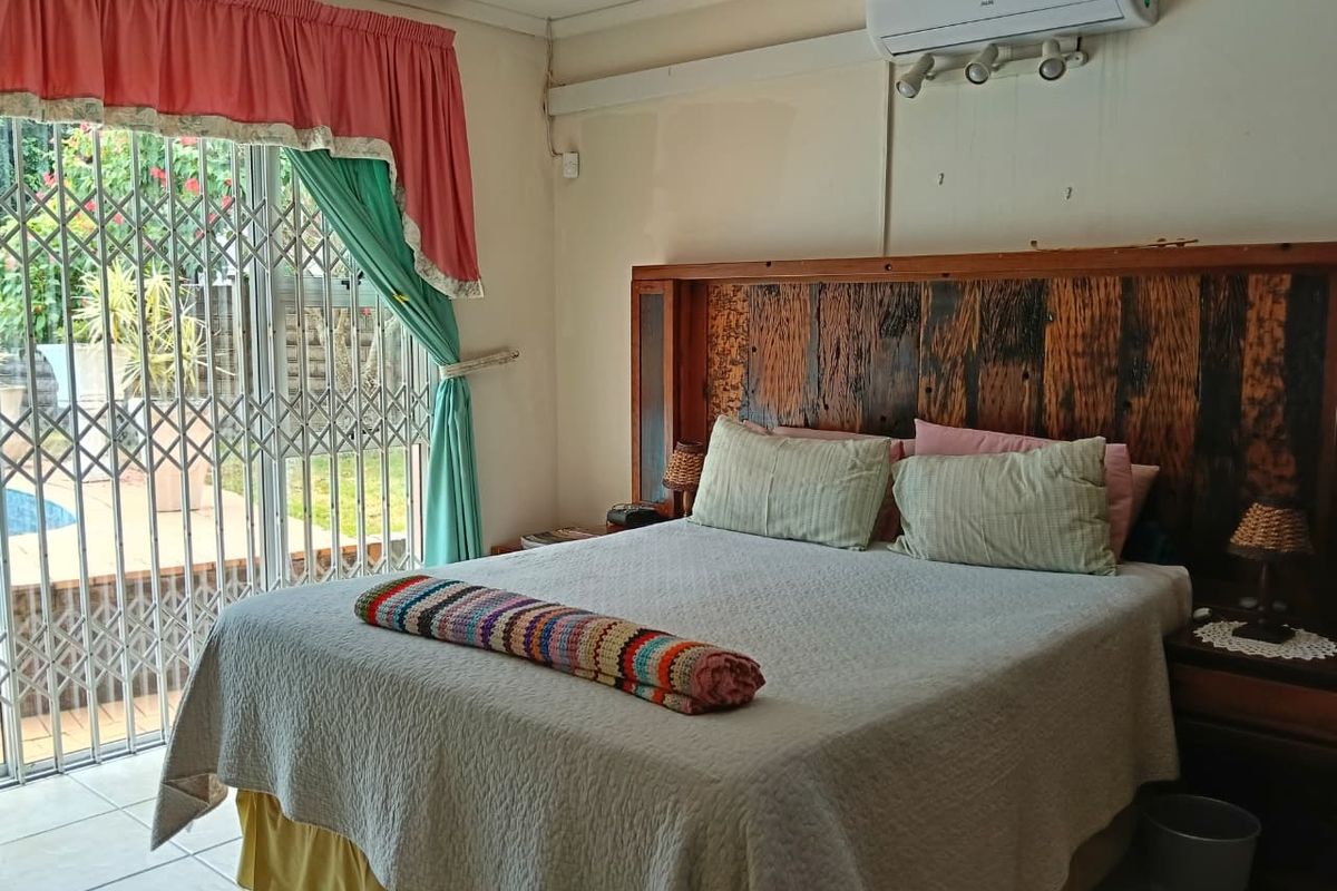 Bedroom featuring tiled flooring, a split-system air conditioner, and a sliding glass door with a security gate providing access to the outdoor area.
