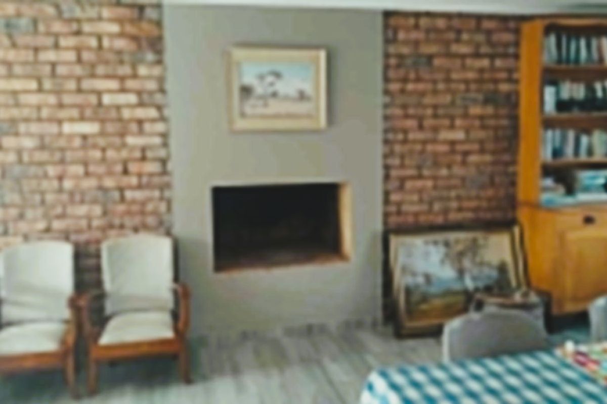 A living room featuring a brick accent wall and a built-in fireplace, providing a rustic focal point for the space.