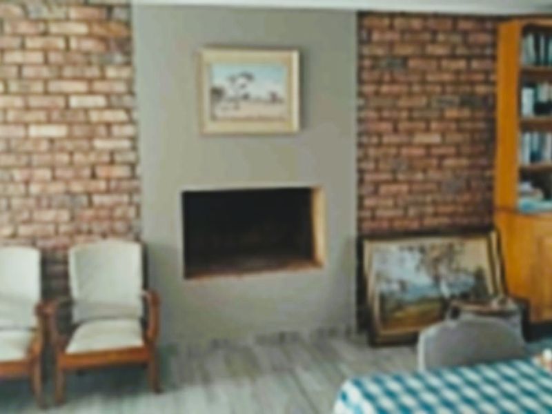 A living room featuring a brick accent wall and a built-in fireplace, providing a rustic focal point for the space.
