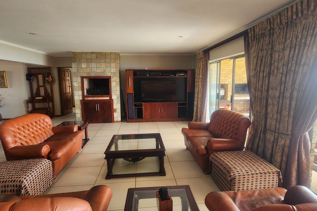 Spacious living room featuring tiled flooring, a built-in fireplace with stone cladding, and large sliding glass doors providing access to the outdoor patio area.