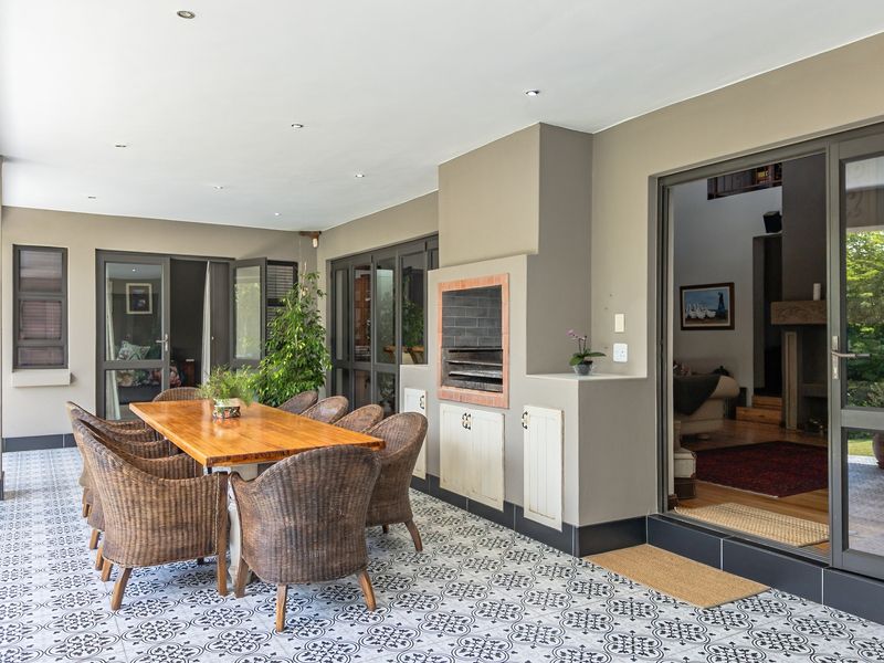 Covered patio featuring patterned floor tiles, recessed downlights, and a built-in braai, providing a seamless transition to the interior living space.
