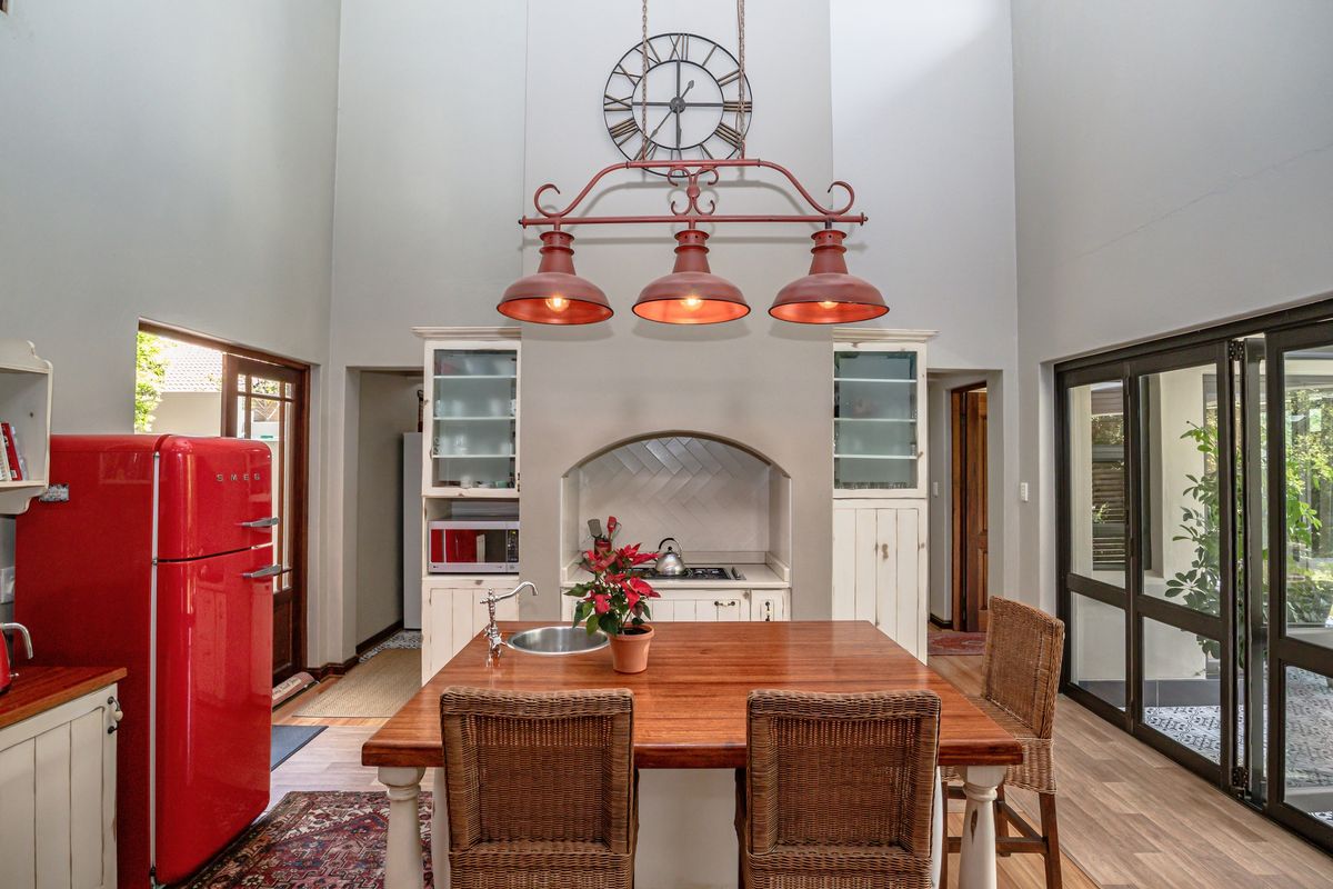 A well-appointed kitchen featuring a central island with a sink, built-in cabinetry, and a distinctive triple pendant light fixture over the workspace.