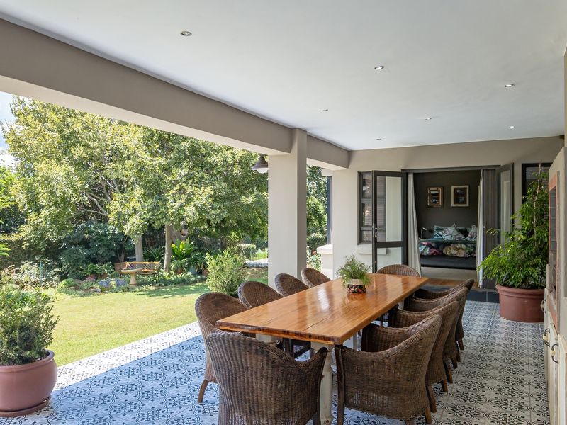 Spacious covered patio featuring patterned floor tiles, recessed lighting, and a built-in braai, offering seamless access to the garden.