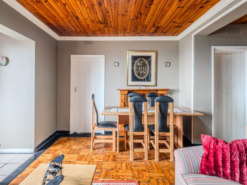 Dining area featuring traditional parquet flooring and a warm timber tongue and groove ceiling, providing a classic foundation for interior updates.