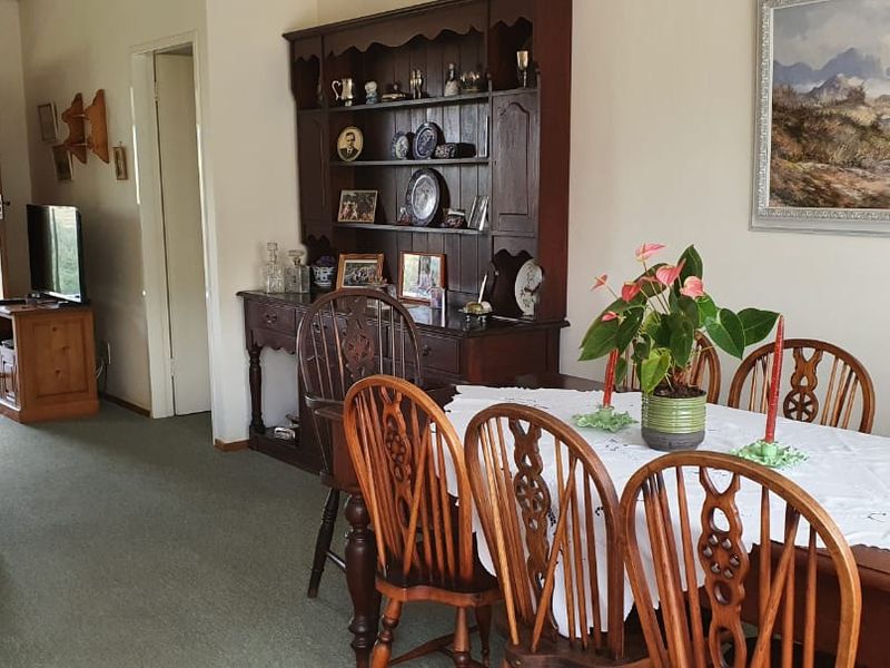 Open-plan living and dining area featuring carpeted flooring and direct access to an outdoor patio space.